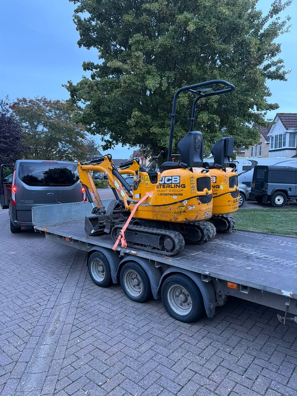 Two Sterling Plant Group JCB micro diggers secured on a trailer for delivery