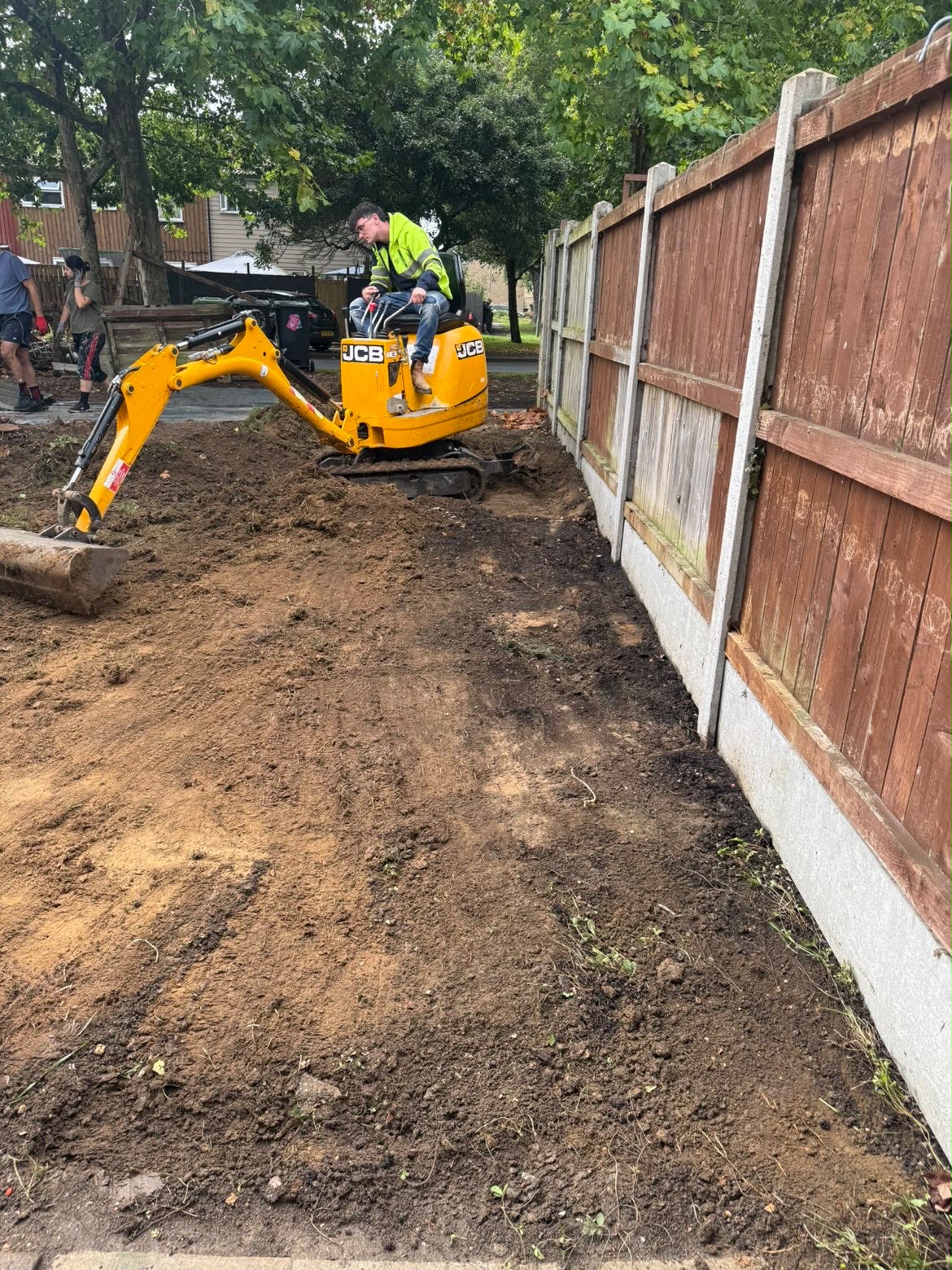 JCB 8008 CTS micro digger working close to a garden boundary fence