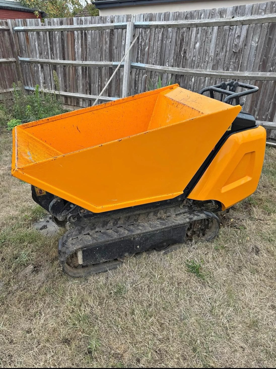 Yellow tracked mini dumper with tipping skip available for hire from Sterling Plant Group