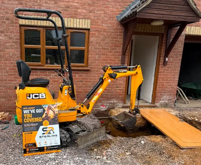 JCB 8008 CTS micro digger working in a tight space next to a doorway