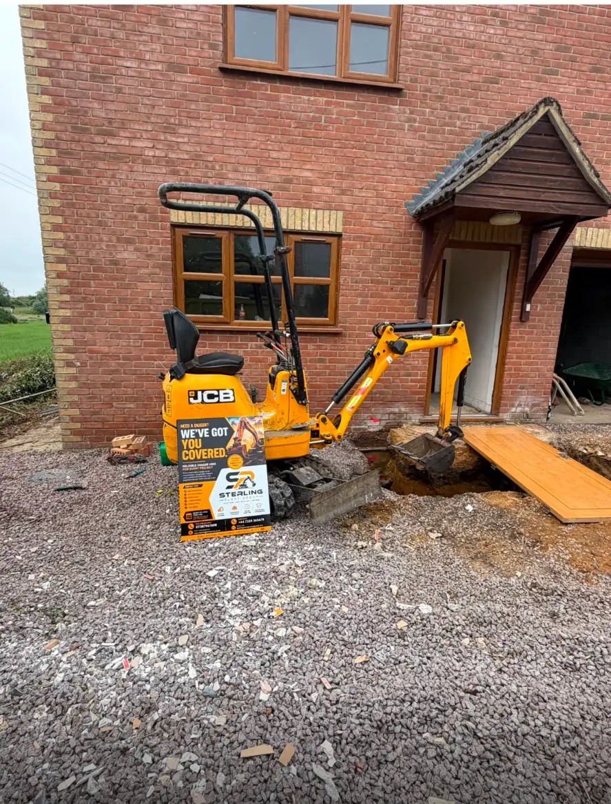 Sterling Plant Group JCB 8008 CTS micro digger digging a trench beside a house